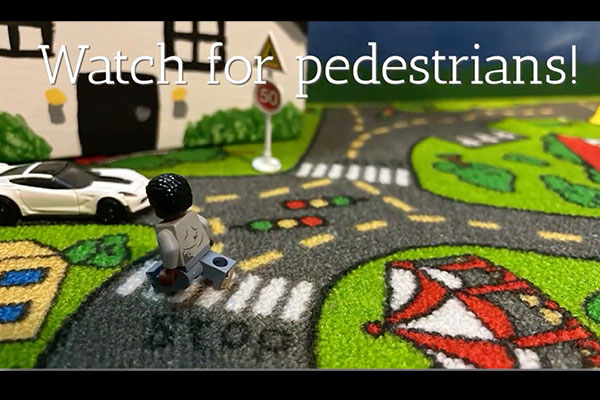 toy car and person on a toy rug that looks like a road