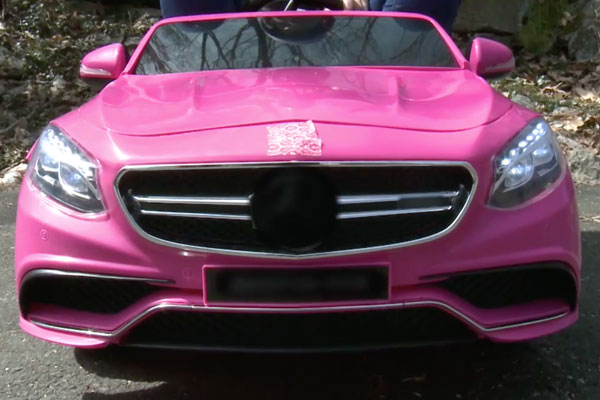 a close up of the front of a pink car