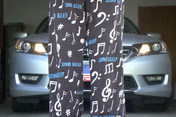 back of a persons legs in sleepy pajamas standing in front of a car