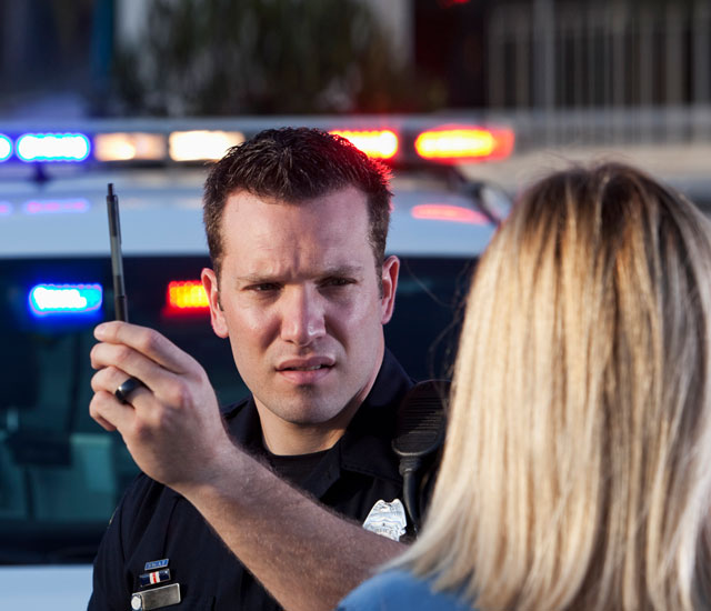police officer conducting a sobriety test to a woman