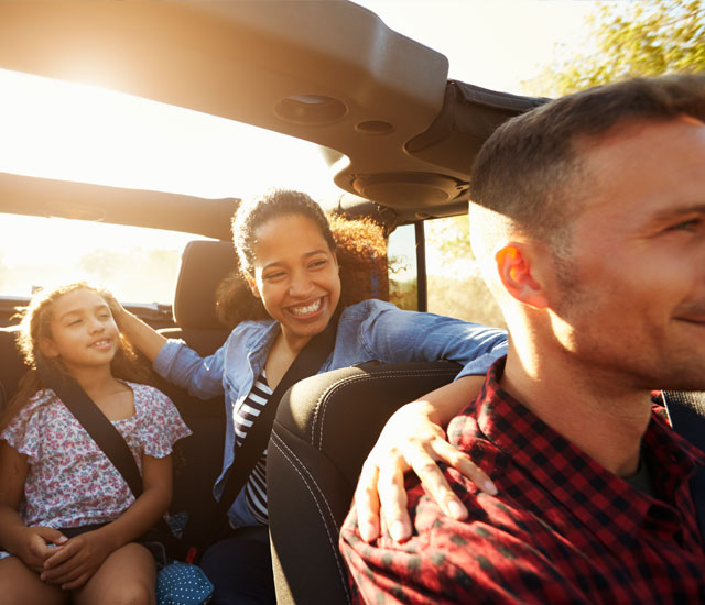 mixed ethnic family in car, focus on backseat passengers