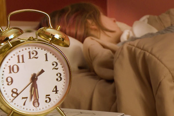an alarm clock and a person sleeping