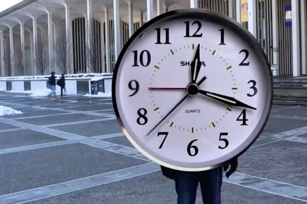 a big clock in a square hiding a person