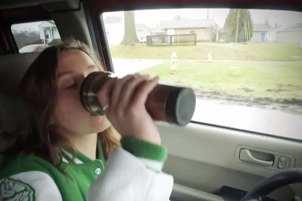 a girl drinking coffee in a car
